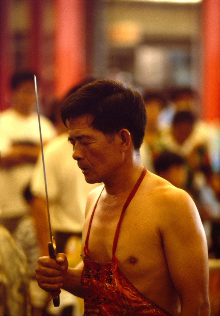 One of the festival participants is concentrating before he cuts himself with the sword