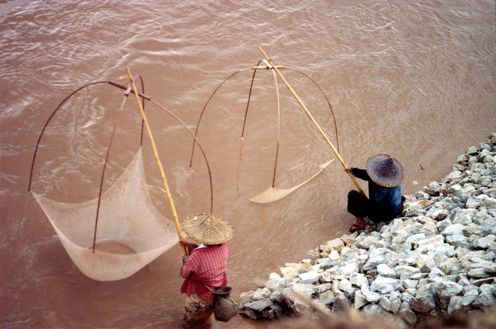 Two women is fishing at the banks of the Mekong River