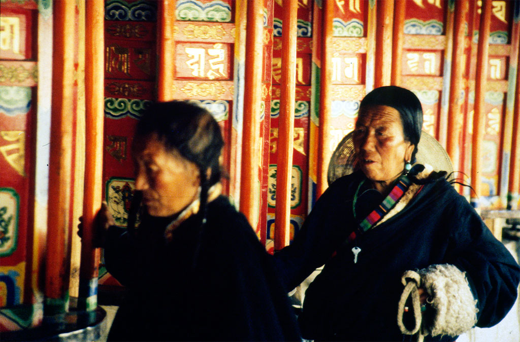 Tibetanske kvinder ved kæmpe bedemøller ved Labrang templet i Xiahe i Gansu provinsen