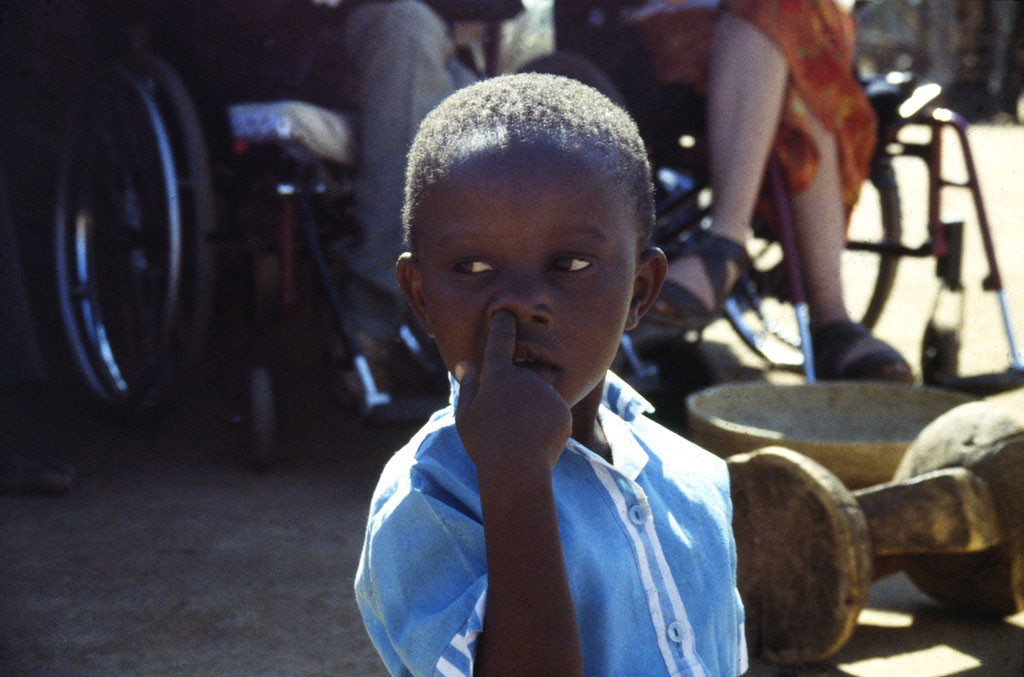 A boy in the village is picking his nose