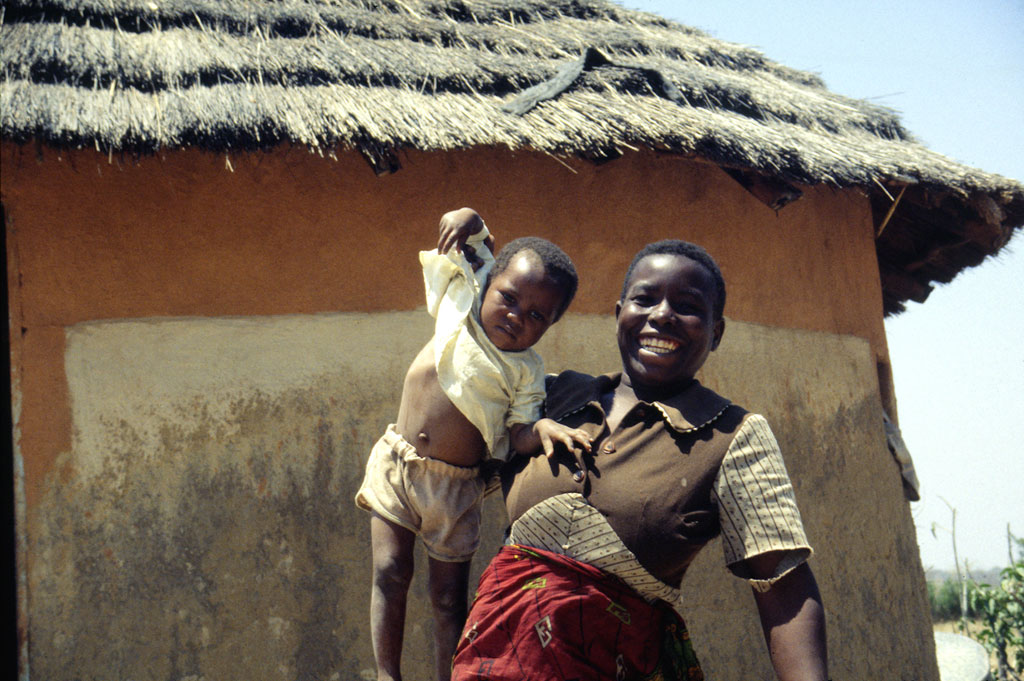 Kvinde fremviser stolt sit barn i en ladsby nær Masvingo